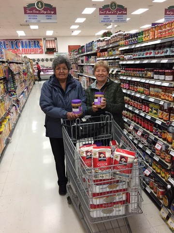 Louisa Alexie and Marj Lubbers filled the grocery cart which was donated to Peace River's Food Bank