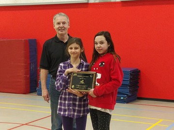 Director of Student Engagement, Attendance and Completion Don Tessier presented Susa Creek students with plaque recognizing the school's overall attendance